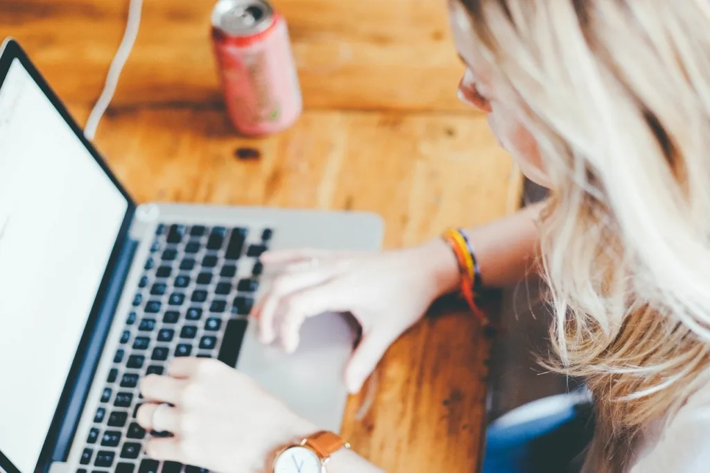 A woman with blond hair working on a laptop