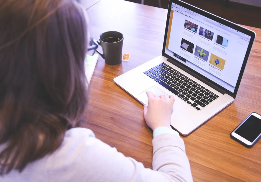 A woman with black hair working on a laptop