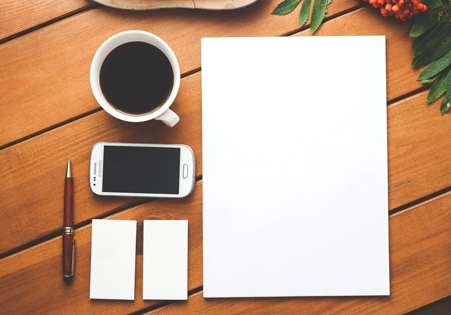 A coffee and a phone kept near stationery