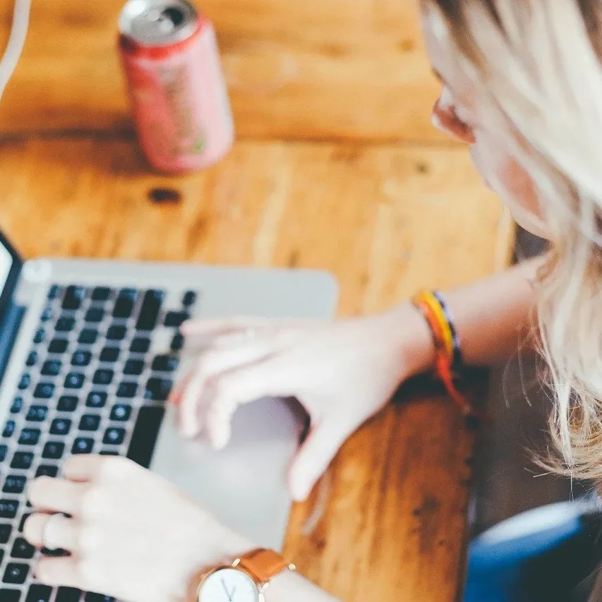 A woman with blond hair working on a laptop